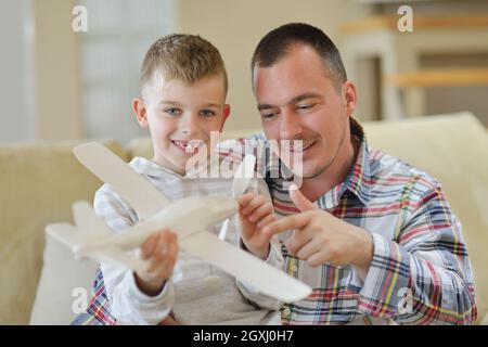 Le père et le fils de l'assemblage à jouet avion accueil moderne salle de séjour piscine Banque D'Images