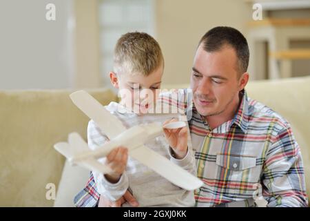 Le père et le fils de l'assemblage à jouet avion accueil moderne salle de séjour piscine Banque D'Images