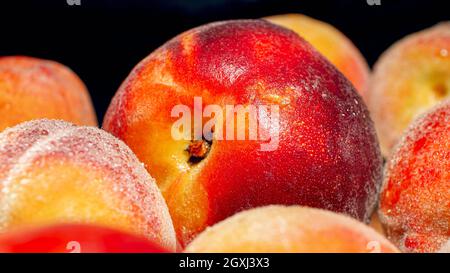 Image macro des pêches et des abricots humides sur le backgorund noir. Arrière-plan abstrait des fruits de saison Banque D'Images