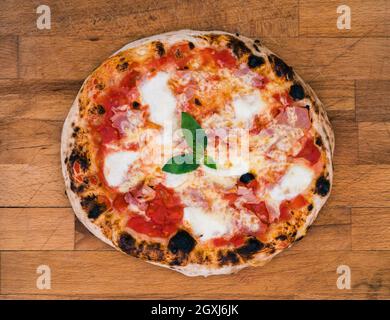 Pizza napolitaine maison sur un bois rustique prêt à manger. Savoureuse et délicieuse pizza italienne traditionnelle peu brûlée sur les bords et est prêt f Banque D'Images