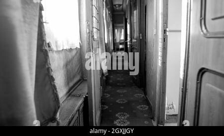 Photo en noir et blanc d'un long couloir étroit dans un wagon d'époque Banque D'Images