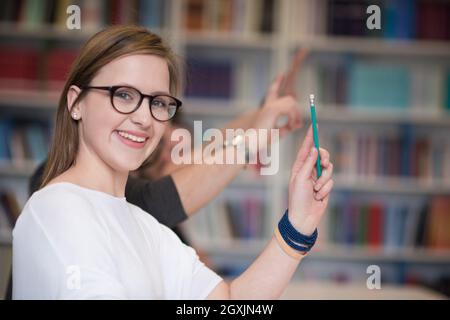 Groupe d'étudiants intelligents soulever Haut les mains à l'école classe de class Banque D'Images