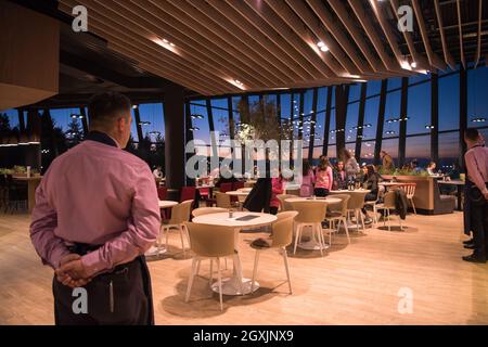 Vue arrière du jeune garçon confiant debout avec les mains derrière le dos dans un restaurant de luxe Banque D'Images