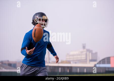 Jeune joueur de football américain en action au cours de la formation sur le terrain Banque D'Images