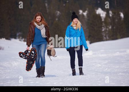 Les amis de belle journée d'hiver ont promenade détendue sur la neige et raquettes holding. Banque D'Images