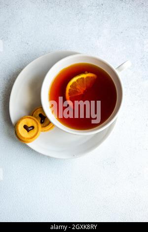 Tasse de thé avec une tranche de citron et deux biscuits Banque D'Images