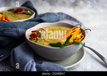 Deux bols de soupe crémeuse aux pois chiches épicés avec piments, origan et garniture de graines de sésame noir Banque D'Images