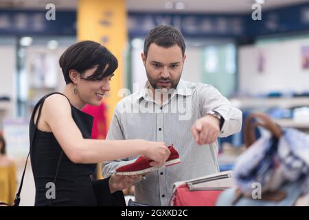 Un jeune beau couple change le regard avec de nouvelles chaussures Magasin de chaussures à Banque D'Images