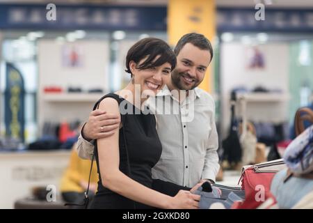 Un jeune beau couple change le regard avec de nouvelles chaussures Magasin de chaussures à Banque D'Images