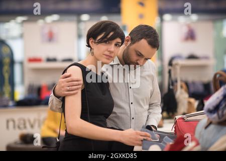 Un jeune beau couple change le regard avec de nouvelles chaussures Magasin de chaussures à Banque D'Images