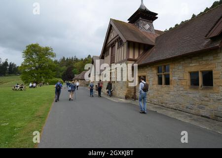 CRAGSIDE Northumberland National Trust maison mur en pierre remparts marcheurs sac à dos chemin de route arbres marcher gens randonneurs tour de randonnée vieux Banque D'Images