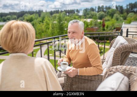 Mari ayant une conversation avec sa femme sur la terrasse Banque D'Images