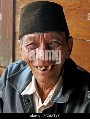 Un homme âgé sur un marché traditionnel portant un chapeau religieux peci, avec un sourire amical à Bukittinggi, Sumatra Ouest, Indonésie. Banque D'Images