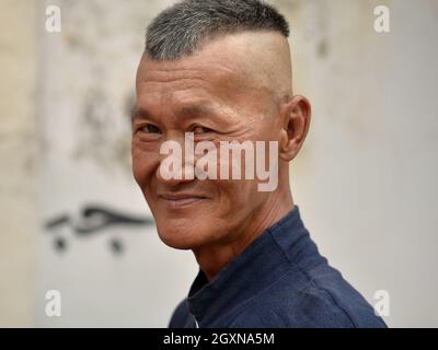 Conducteur traditionnel malaisien de trishaw vieux avec poses de coiffure de contre-dépouille moderne pour la caméra. Banque D'Images