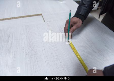 Travailleur carpenter distance de mesure pour le forage de trous dans de nouveaux meubles Banque D'Images