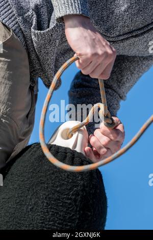 Jeune homme nouant un nœud dans une corde d'aile, marins sur un catamaran de voile, voyage de voile, Dodécanèse, Grèce Banque D'Images