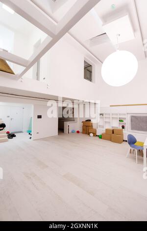 Intérieur d'un vide élégant et moderne espace ouvert appartement à deux niveaux avec murs blancs et grand lustre rond au milieu prêt à se déplacer Banque D'Images