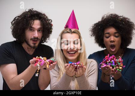 Multiethnics parti confettis jeunes heureux nouvel an fête de groupe en dansant et s'amuser à la maison Banque D'Images