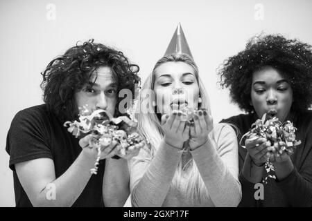 Multiethnics parti confettis jeunes heureux nouvel an fête de groupe en dansant et s'amuser à la maison Banque D'Images