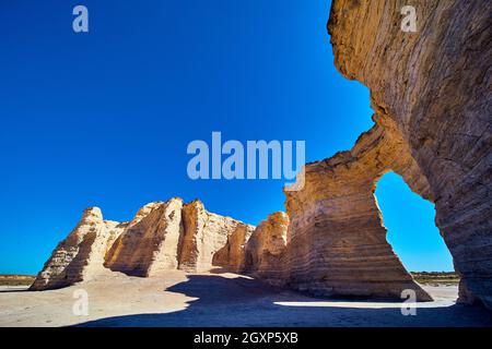 Piliers de roche blanche dans un désert plat avec un ciel bleu vif Banque D'Images