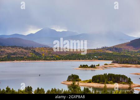 Lac avec de petites îles et des montagnes en arrière-plan avec la pluie verser Banque D'Images