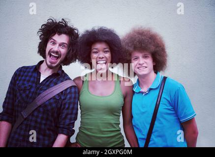 Portrait de groupe multiethnique de professionnels trois amis dans des vêtements décontractés et rire permanent Banque D'Images