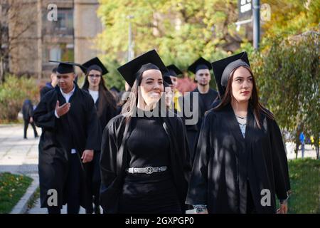L'éducation, l'obtention du diplôme et les gens concept - groupe de professionnels et étudiants internationaux dans les conseils de mortier et d'un baccalauréat diplômes avec robes Banque D'Images