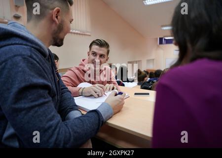 En classe élèves multiethniques à l'écoute d'un conférencier et à l'écriture dans des cahiers de notes. Smart Young People Study à l'université. Banque D'Images