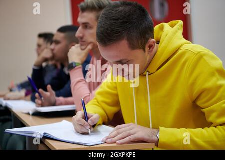 En classe élèves multiethniques à l'écoute d'un conférencier et à l'écriture dans des cahiers de notes. Smart Young People Study à l'université. Banque D'Images