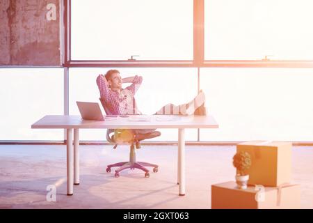 Young businessman Taking a break sur chantier lors de la vérification de documents et de travail de l'entreprise à l'aide d'un ordinateur portable avec la lumière du soleil par Banque D'Images