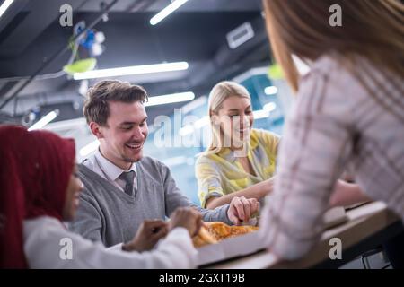 Friendly diverses affaires multiethniques de manger la pizza de l'équipe partage ensemble dans le bureau de démarrage, collaborateurs du groupe multiracial du personnel bénéficiant d'briser parler l Banque D'Images