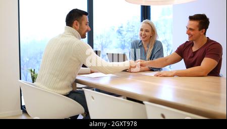 Jeune couple riche acheter un appartement, propriété, maison, conclure un contrat avec un agent immobilier. Signe un accord avec le vendeur Banque D'Images