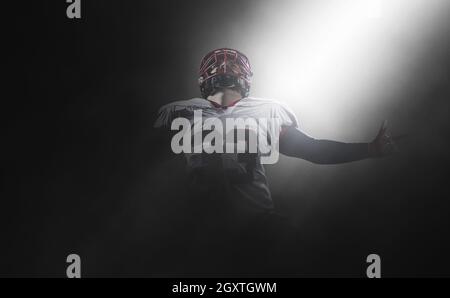 Joueur de football américain célèbre après avoir marqué un touché sur terrain de nuit Banque D'Images