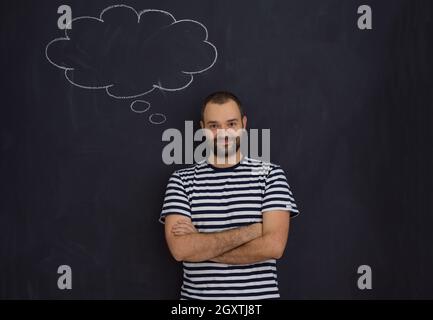 Jeune futur père de penser à des noms pour son bébé à venir à les écrire sur un tableau noir Banque D'Images