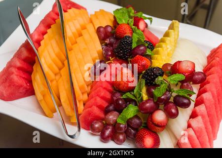 Des fruits fraîchement coupés sur une assiette blanche comme dessert. Banque D'Images