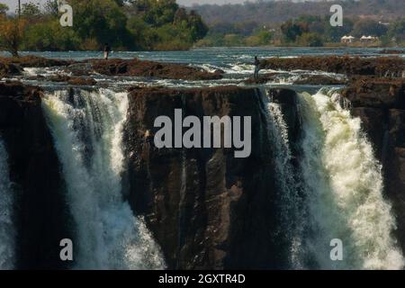 Les Africains pêchent au-dessus des puissantes chutes Victoria sur le fleuve Zambèze, juste à la frontière de Zâmbia et du Zimbabwe Banque D'Images