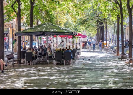 Barcelone, Espagne - 19 septembre 2021: Vue de quelques personnes marchant le long des Ramblas à Barcelone (boulevard) et d'autres ayant un verre sur la terrasse Banque D'Images