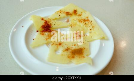 Assiette de fromage à fromage Swiss dentelé avec poivre rouge Cayenne et paprika Banque D'Images