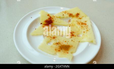 Assiette de fromage à fromage Swiss dentelé avec poivre rouge Cayenne et paprika Banque D'Images