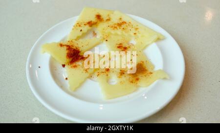 Assiette de fromage à fromage Swiss dentelé avec poivre rouge Cayenne et paprika Banque D'Images