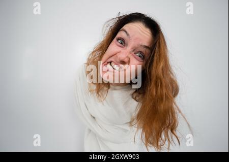 Portrait en gros plan d'une femme aliénée en blouson sur fond blanc. Banque D'Images