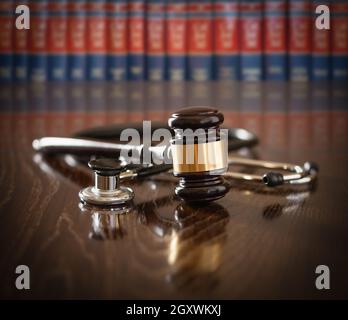 Gavel et stéthoscope sur table en bois avec livres de droit en arrière-plan. Banque D'Images