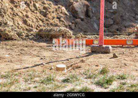 La ligne Guide, niveau et Sledge Hammer At Construction Site Banque D'Images