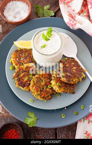 Beignets de légumes aux courgettes salés avec une sauce à la crème aigre Banque D'Images