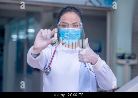 Gros plan médecin ou infirmières montrant des flacons de vaccin antiviral prouvés.Docteur donnant la vaccination prophylactique contre le VPH. Banque D'Images