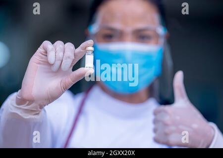 Gros plan médecin ou infirmières montrant des flacons de vaccin antiviral prouvés.Docteur donnant la vaccination prophylactique contre le VPH. Banque D'Images