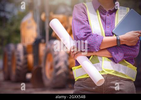 Femme ingénieurs de construction de vérifier la disposition et iPad numérique .Contremaître travaillant sur le chantier de construction. Banque D'Images