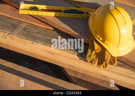 La construction du résumé de casque, gants et niveau reposant sur des planches en bois. Banque D'Images