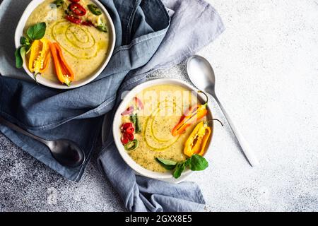 Deux bols de soupe crémeuse aux pois chiches épicés avec piments, origan et garniture de graines de sésame noir Banque D'Images