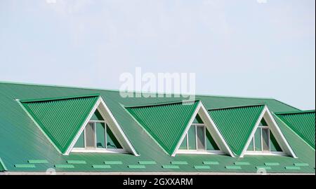 La chambre avec fenêtres en plastique et un toit vert de feuille de carton ondulé. Roofing d'un profil en métal de forme ondulée sur la chambre avec des fenêtres en plastique. Toit vert Banque D'Images